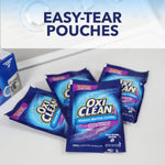 Staged photo of several OxiClean washing machine cleaner single-use pouches on a surface under text 'Easy-Tear Pouches'