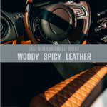 Close crop of a car interior steering wheel and quilted leather seat with overlaid text 'Woody Spicy Leather' scent description.