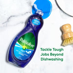 Single tilted Palmolive Ultra Oxy bottle on a marble surface with cap open and a dish brush nearby and promotional text