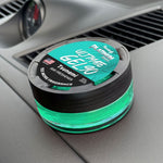 Close-up of a turquoise Paradise Air Ultimate Gel 90 Tsunami air freshener on a car dashboard showing the branded top label.