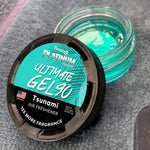 Opened turquoise gel air freshener jar with black vented lid beside it, label reads ‘Platinum Ultimate Gel 90 Tsunami’.