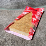 Red Paradise Air Super Organic cherry pouch opened to show the rectangular fibrous scent pad inside.