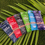 Six Paradise Air Super Organic under-seat air freshener pouches fanned out on green foliage, Tropic Twist visible in the center.