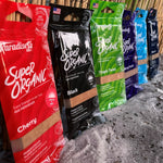 Row of Paradise Air Super Organic air freshener pouches in multiple colors including a red cherry pouch at the front.