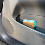 Paradise Air Super Organic Tsunami pack tucked into a car door pocket showing the triangular brown insert