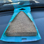 Paradise Air Super Organic Tsunami pack with triangular felt air freshener photographed on a vehicle dashboard