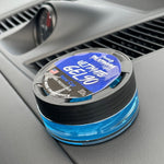 Paradise Platinum Ultimate GEL90 New Car air freshener sitting on a car dashboard showing blue gel and branded label