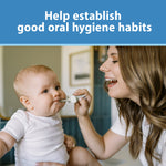 Parent smiling while using a mint elephant toothbrush to brush an infant's teeth, lifestyle scene