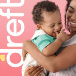 Smiling parent holding a laughing baby against a pink backdrop with partial Dreft logo visible
