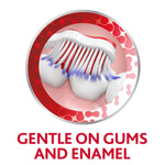 Illustration of a toothbrush gently cleaning tooth enamel and gum line with multicolored bristles in circular frame