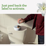 Person peeling label off an Arm & Hammer Essentials container placed on a toilet tank with instruction text above