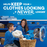 Lifestyle image of a smiling woman and child doing laundry beside a front-load washing machine with folded towels above