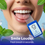 Close-up of a person placing a translucent breath strip on their tongue from a blue Grin Strips 24 strips case, mint leaves visible