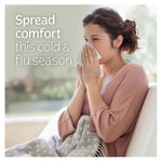 Person seated on a couch blowing their nose into a tissue with copy encouraging comfort during cold and flu season