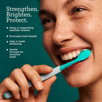 Close-up of a smiling person brushing with a teal toothbrush alongside text highlighting strengthening, brightening, and protection.