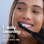 Close-up lifestyle image of a smiling person using a black Oral‑B electric toothbrush on their teeth with overlay text about daily cleaning.