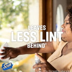 Person cleaning a glass surface with a Scott paper towel alongside overlay text stating leaves less lint behind