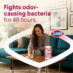 Lifestyle image of a person wiping a wooden table with a Clorox Scentiva canister visible on the table and product logo overlay