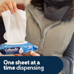 Person dispensing a single sheet from a blue Cottonelle Fresh Care flip-top pack with 'One sheet at a time dispensing' caption