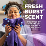Person holding and smelling a purple towel with overlay text promoting the Fresh Burst scent and fragrance technology