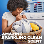 Smiling person smelling freshly laundered towels from a laundry basket in front of a washing machine with scent claim text