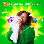 Person smelling a towel with joyful expression surrounded by floral graphics and the text ‘sniff the difference’