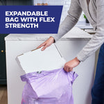 Person holding a purple Hefty trash bag open while tipping a pizza box into it, promoting expandable bag with flex strength