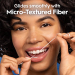 Close portrait of a smiling person flossing with Oral-B Glide; overlay text highlights micro-textured fiber and smooth glide.