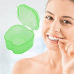 Smiling person holding a clear aligner next to an open translucent green retainer storage box on a light background