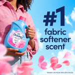 Person holding a Downy April Fresh bottle with falling pink petals and large text declaring #1 fabric softener scent.