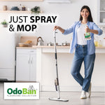 Person in casual clothes holding an OdoBan Luxury Vinyl spray bottle next to a spray mop in a bright kitchen scene