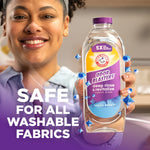 Smiling person holding a bottle of ARM & HAMMER Odor Blasters fabric rinse with safe-for-washables claim