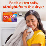 Person hugging a soft blanket next to a washer with a small Bounce French Lavender box and softness claim