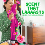 Person hugging a bright pink garment with hibiscus flower graphics and text 'SCENT THAT LAAAASTS' in green