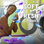 Lifestyle image of a smiling person hugging a towel beside a washing machine with Gain Odor Defense text and decorative petals
