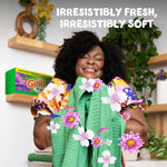 Person hugging fresh towels with Gain dryer sheets box and floral graphics, slogan about freshness and softness