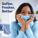 Person in a light blue sweater holding the collar to their face with copy reading “Softer, Fresher, Better”