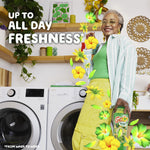 Smiling person standing in a laundry room holding a Gain scent booster bottle with text promoting all-day freshness.