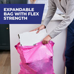 Person placing a cardboard box into an expandable bright pink trash bag, captioned 'Expandable bag with flex strength'