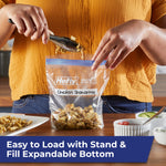 Person loading cooked chicken into a Hefty press-to-close quart bag on a kitchen counter