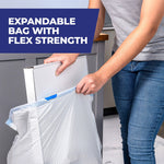 Person placing a box into a white Hefty bag in a kitchen with overlay text about expandable bag and flex strength