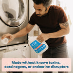 Lifestyle photo of a person pouring ECOS laundry detergent into a washing machine drawer at home