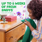 Person smelling a green sweater with floating flowers and text claiming up to six weeks of fresh sniffs