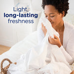 Person smelling a white sheet with text reading 'Light, long-lasting freshness' advertising scent benefits.