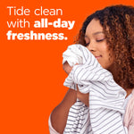 Smiling person smelling a striped shirt against an orange background with text promoting Tide clean and all-day freshness.