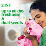 Person smiling and smelling a pink shirt with cherries and rose petals graphic promoting dual scents