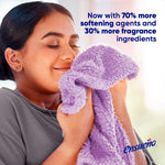 Person smelling a soft purple towel with message about increased softening agents and fragrance