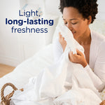 Person smelling a clean white sheet with text reading “Light, long-lasting freshness” in product lifestyle image.