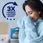Person smelling a blue towel with a Downy bottle and '3X longer lasting scent' graphic in the background
