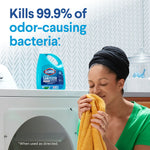 Lifestyle image of person smelling a yellow towel with Clorox Laundry Sanitizer bottle on dryer and text about killing odor-causing bacteria